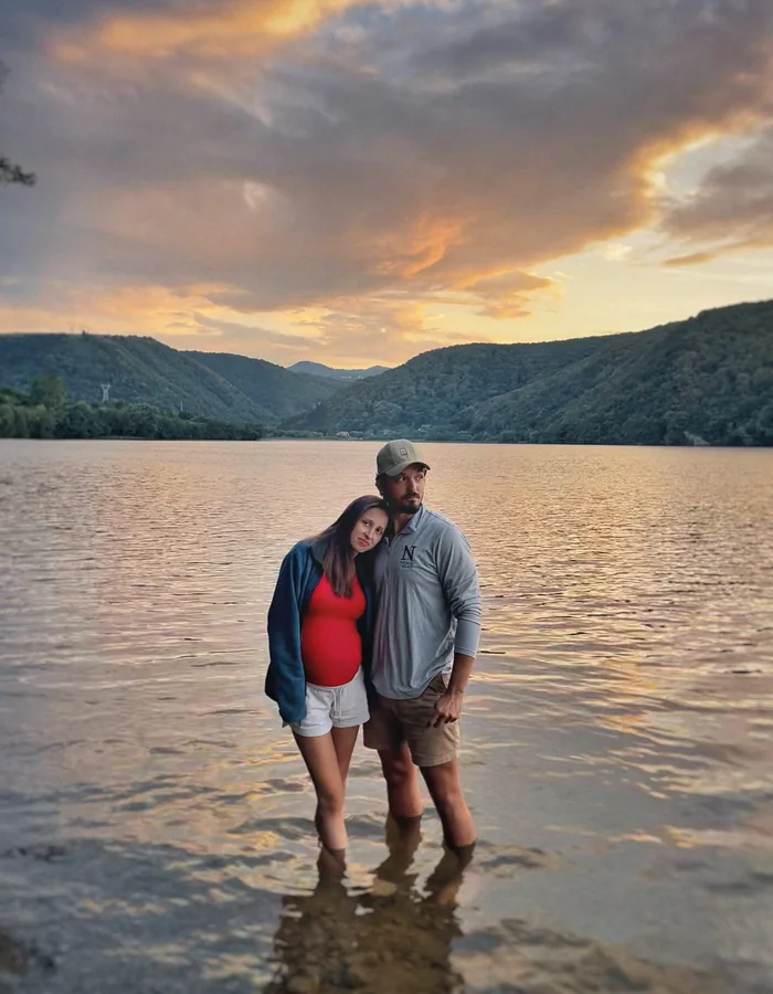 Dr. Dan Serban and his wife standing in a lake at sunset