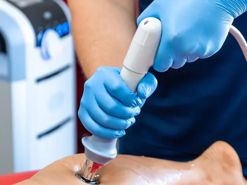 Shockwave treatment being applied to a client's lower leg