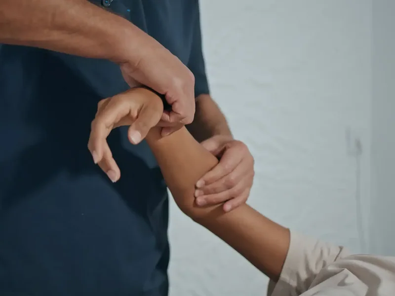 Therapist releasing tissue along a client's forearm and elbow