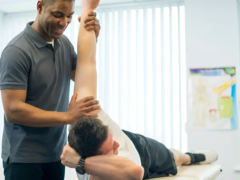 Therapist stretching a client's arm while lying supine