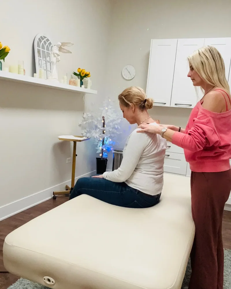 Therapist working on a seated client's shoulders