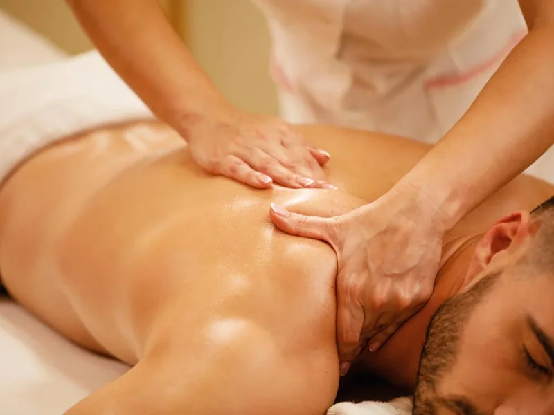 Therapist working a client's upper back on a treatment table